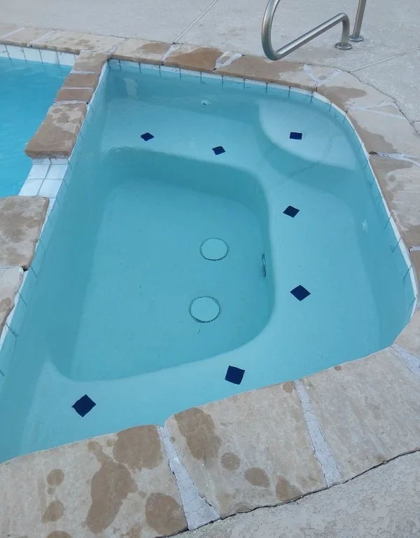 Spa water, white entry steps and small blue accent tiles.