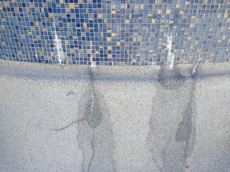 Calcium buildup on pool tile before cleaning