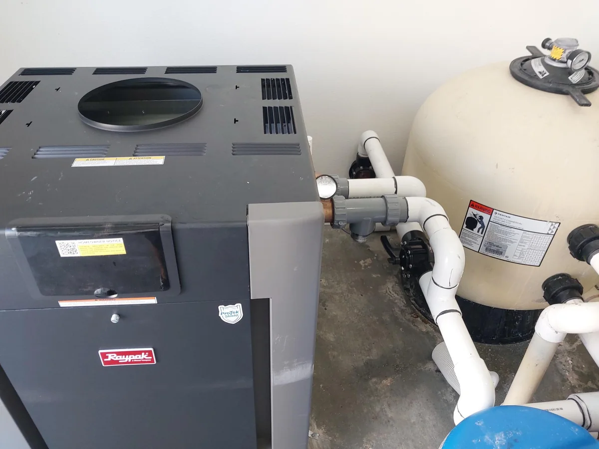 Pool heater and large filter tank in an equipment room.