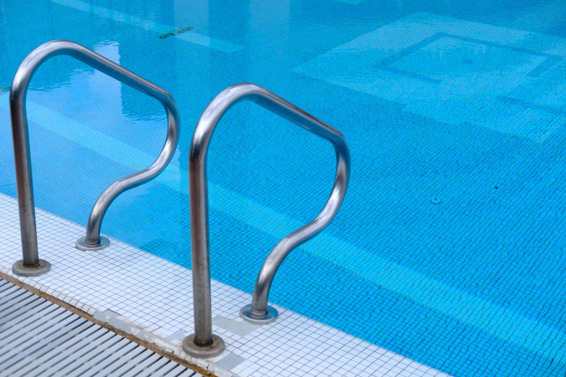 Clear blue pool with stainless steel entry rails