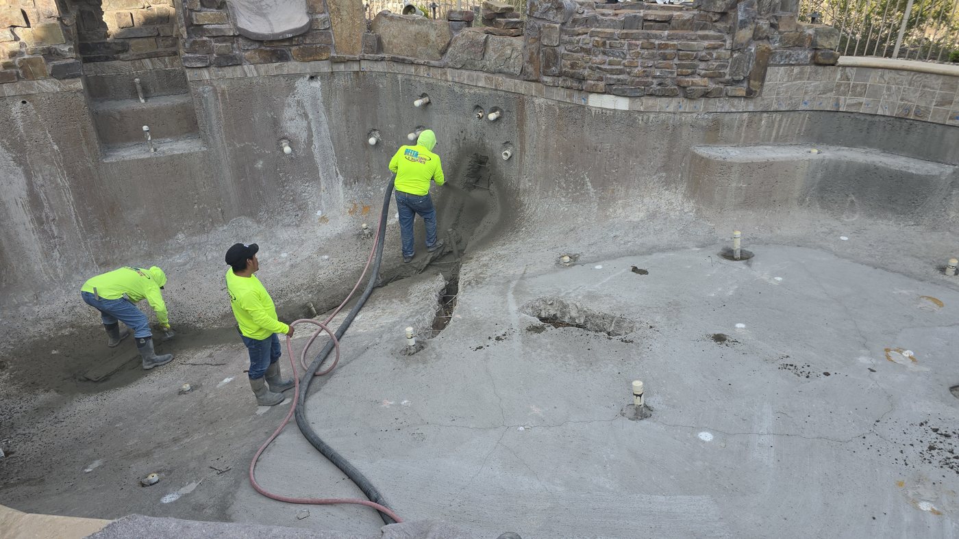 Crew preparing an empty pool for a remodel