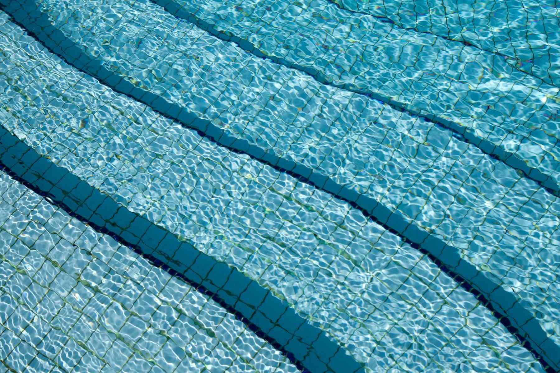 Clear blue pool water over tiled lane lines