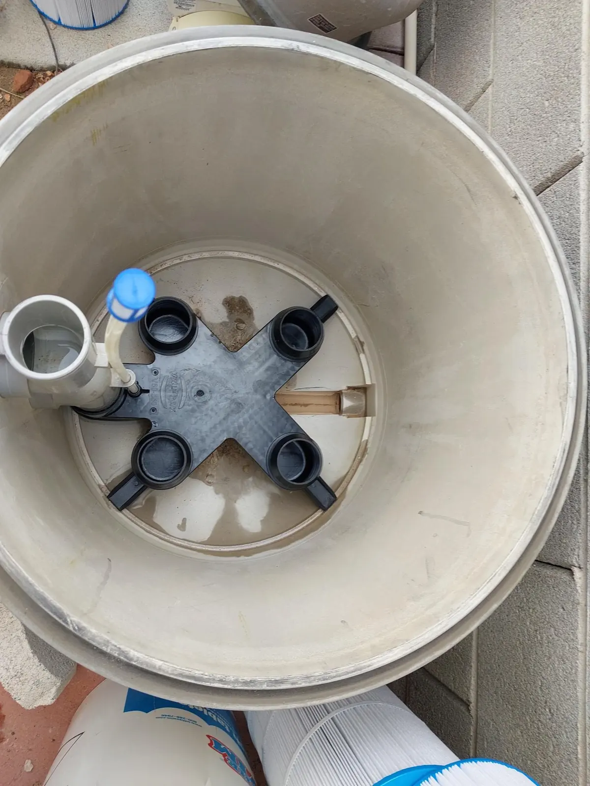 Open cartridge-filter tank with the cartridges removed.