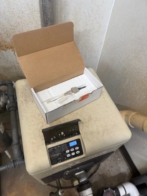 Pool heater control circuit board exposed during service.