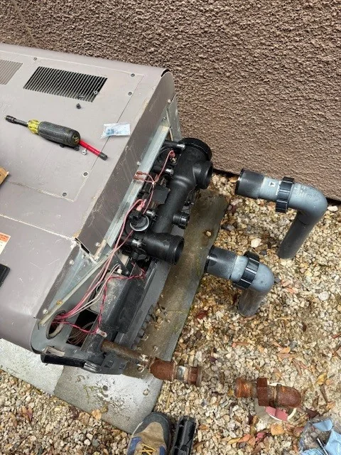 Open heater manifold area with a screwdriver beside the cabinet.