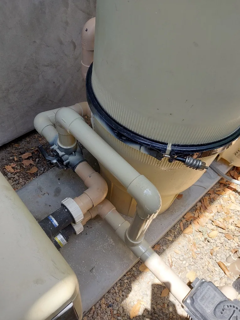 Filter tank clamp and connected PVC plumbing.