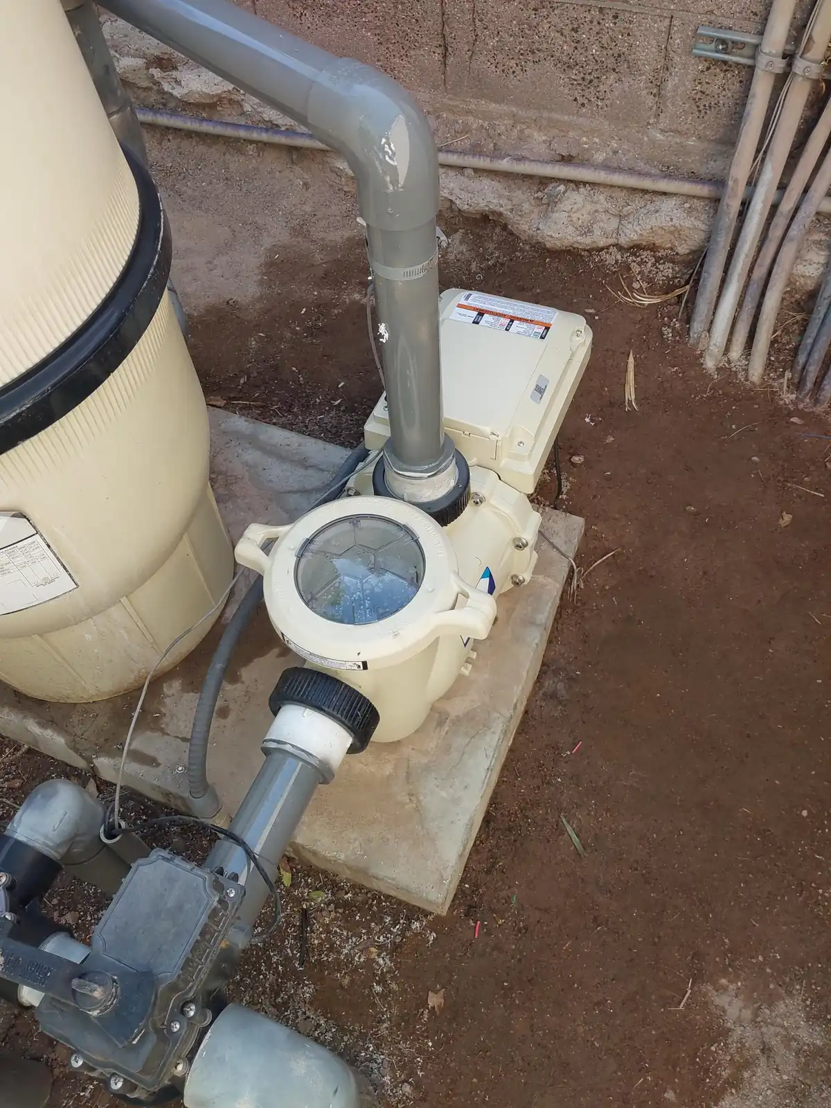 Pool pump and pipe connections at a residential equipment pad.