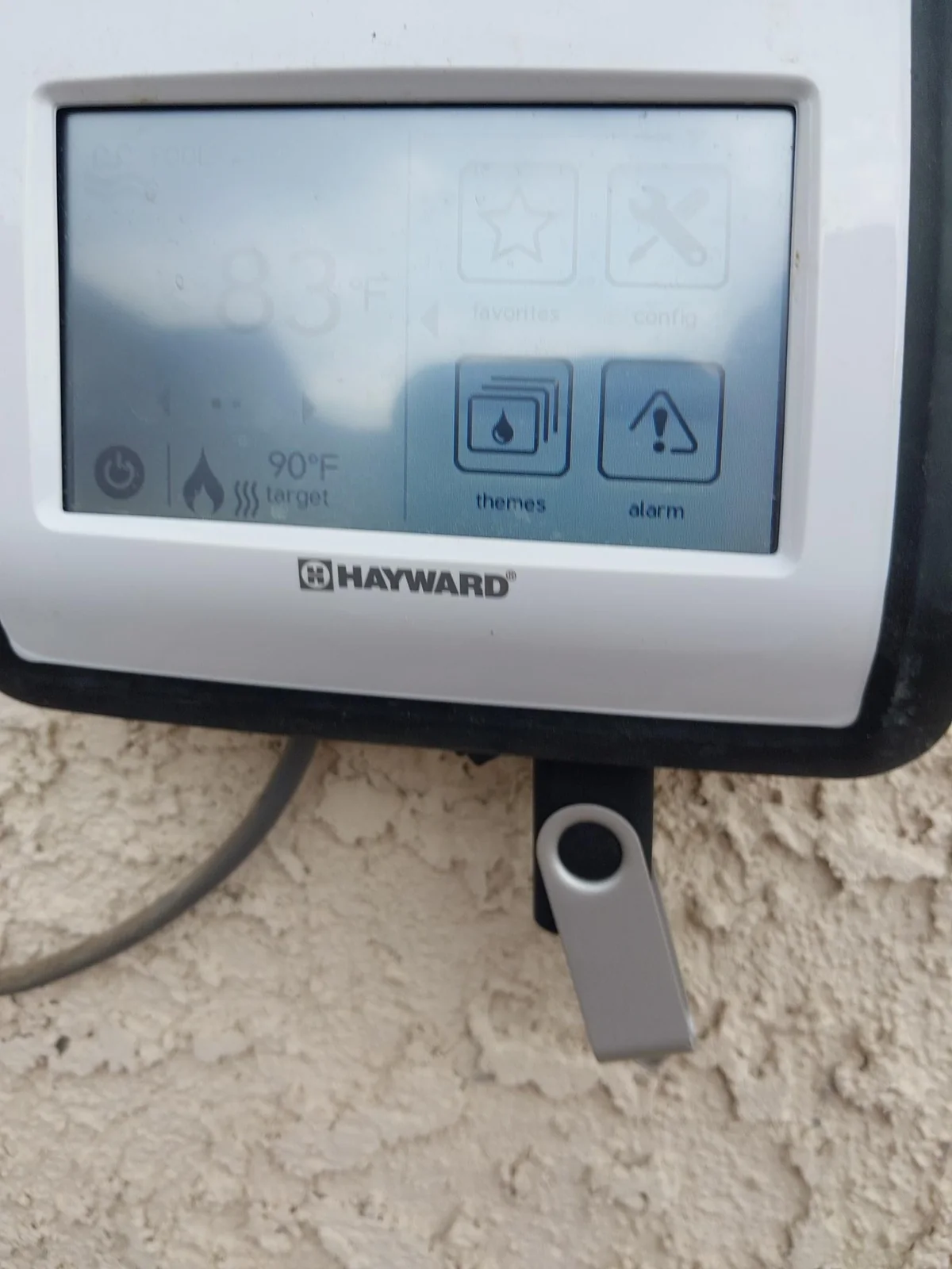 Pool automation touchscreen and surrounding control cabinet.