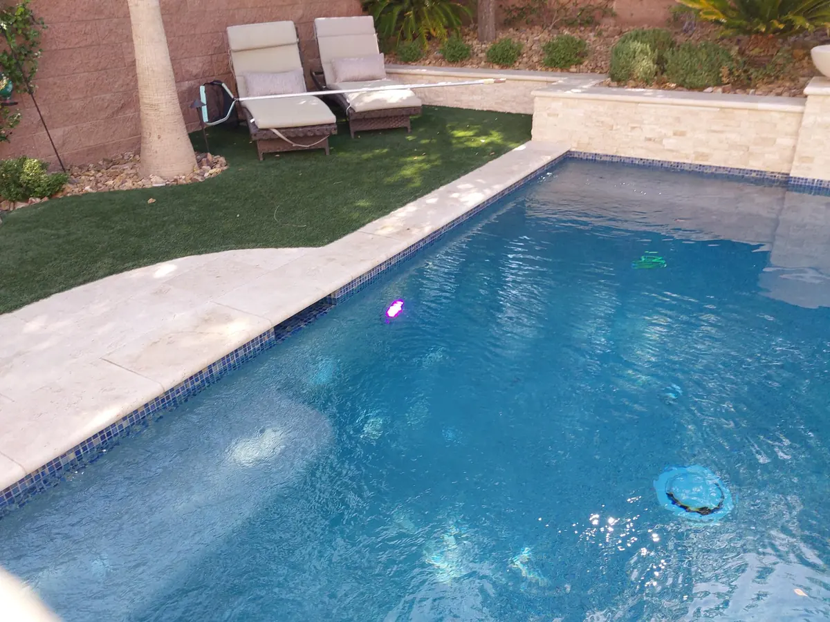 Underwater pool light glowing beside the pool steps.