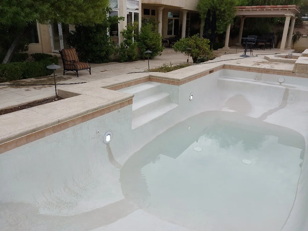 Drained pool and entry steps during lighting work.