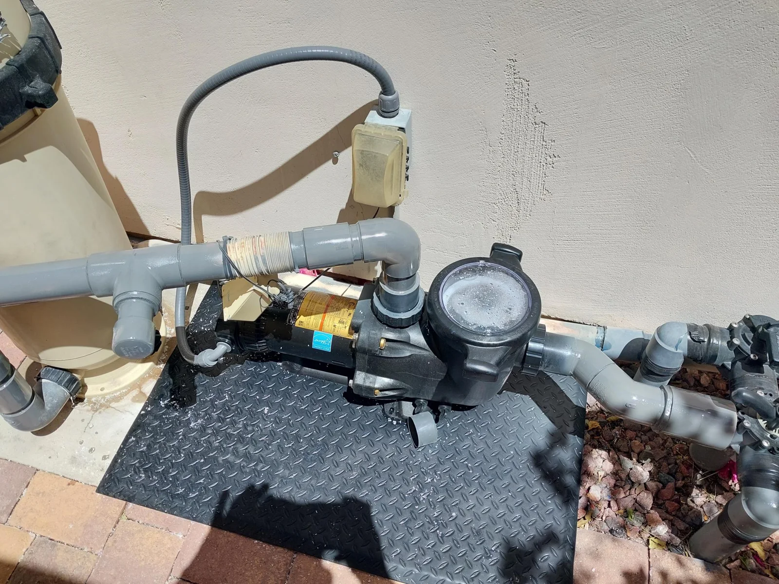 Installed variable-speed pool pump and connected residential plumbing.