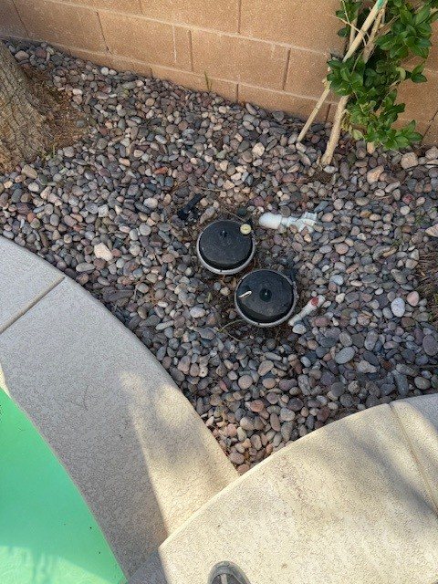 In-floor valve canister beside a pool deck