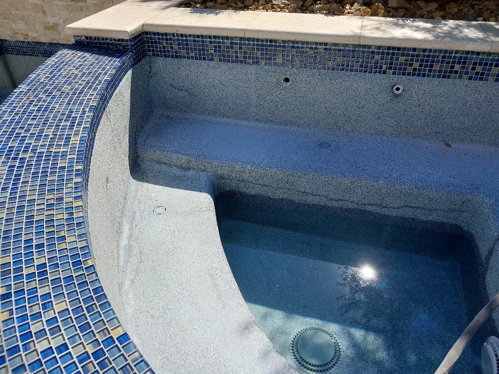 Blue glass mosaic tile on a raised spa wall
