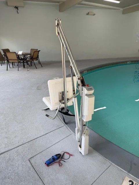 Pool lift beside an indoor pool deck.