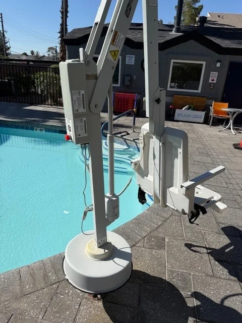 Pool lift mounted beside an outdoor swimming pool.