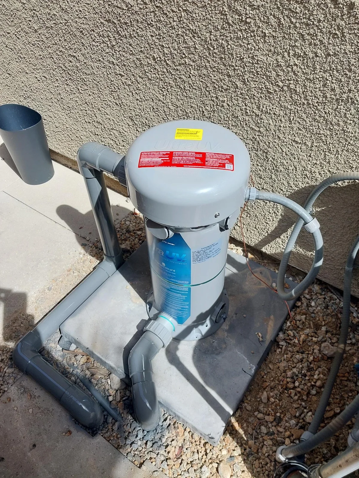 UV treatment housing connected to pool equipment plumbing.