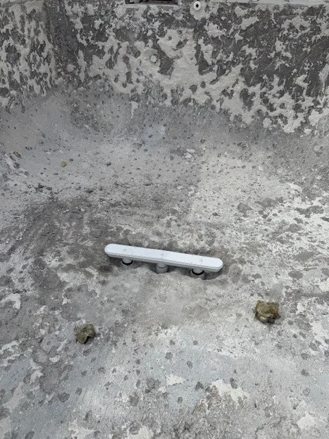 Main drain assembly during installation in an empty pool.