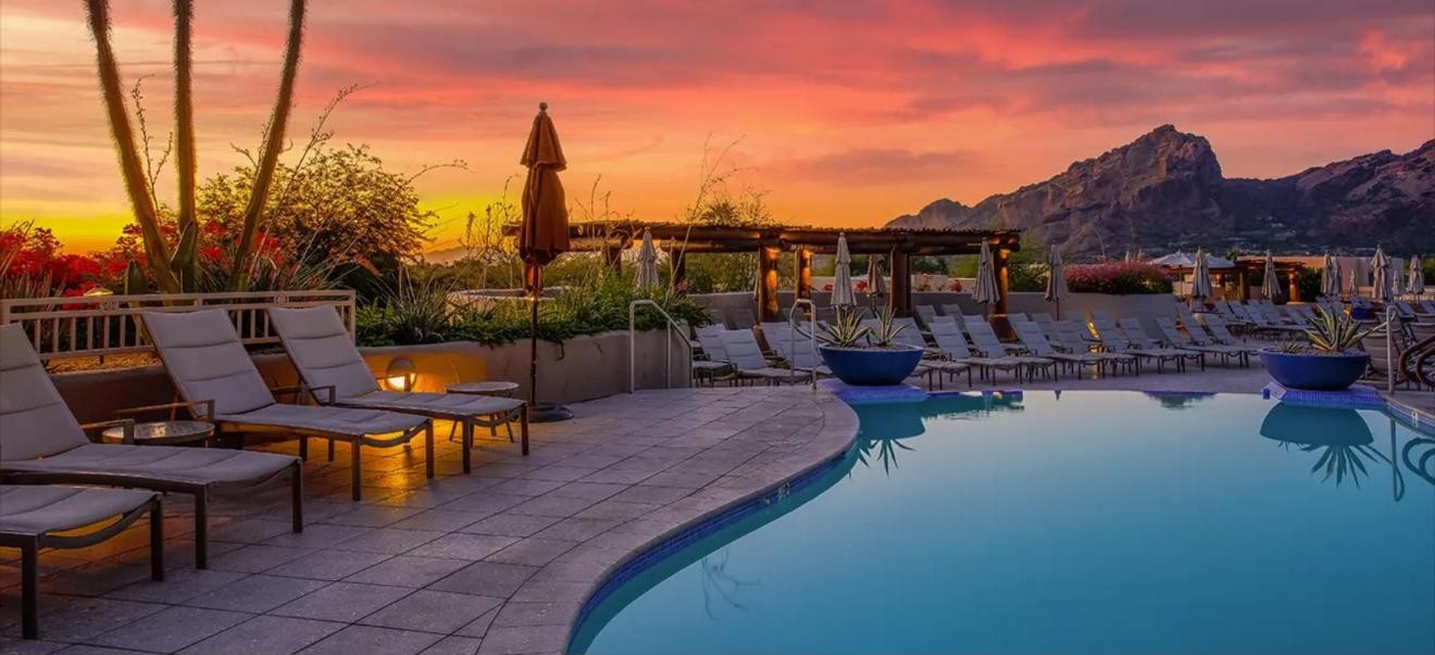 Backyard pool at sunset with desert mountains