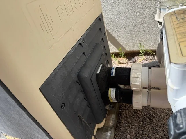 Installed pool heater beside pipe connections.