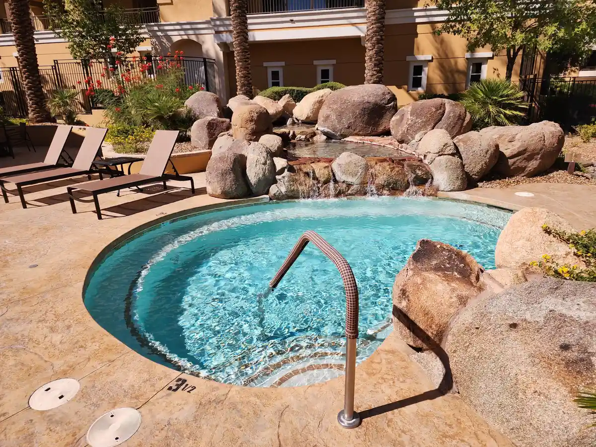 Clear water beneath a rock waterfall at an outdoor spa.