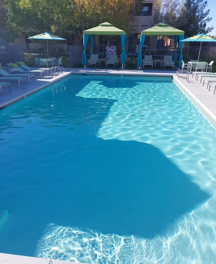 Pool or spa water beside deck features.